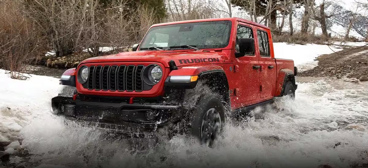 imagen de jeep gladiator rojo cruzando por el agua que se encuentra debajo del header